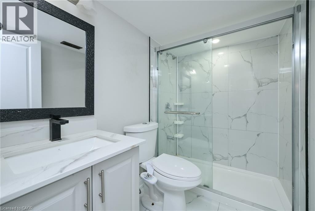 White vanity with integrated sink, black-framed mirror, and matte black faucet - 64 Maple Cider Street, Caledon, ON
