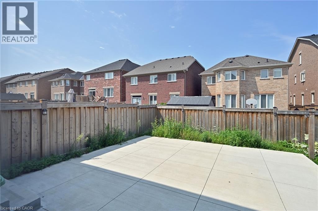 Expansive concrete patio with a full privacy fence - 64 Maple Cider Street, Caledon, ON