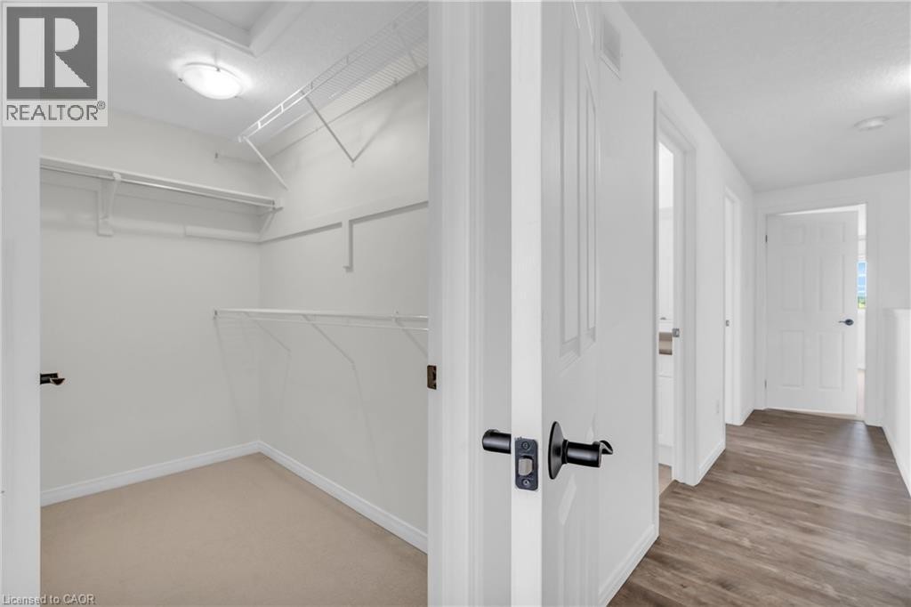 Walk-in closet with wire shelving and plush carpeting - 50 Howe Drive Unit# 19B, Kitchener, ON