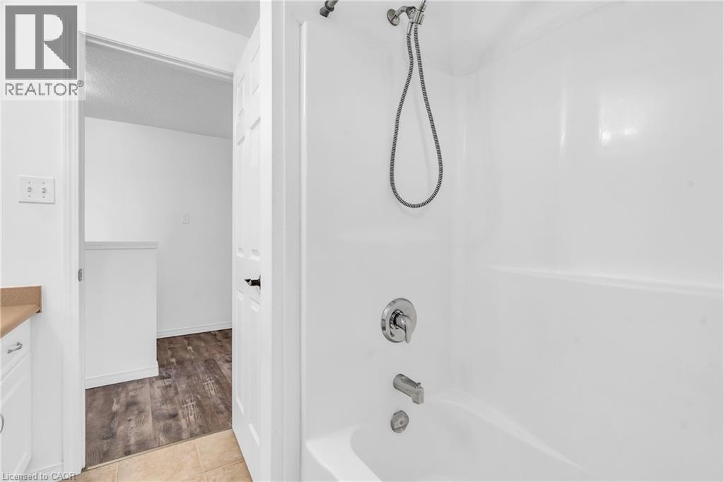 White bathtub and shower combination with chrome fixtures - 50 Howe Drive Unit# 19B, Kitchener, ON