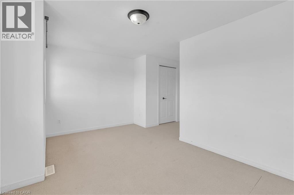 Neutral-toned carpeting, white painted walls, and a flush-mount ceiling light - 50 Howe Drive Unit# 19B, Kitchener, ON