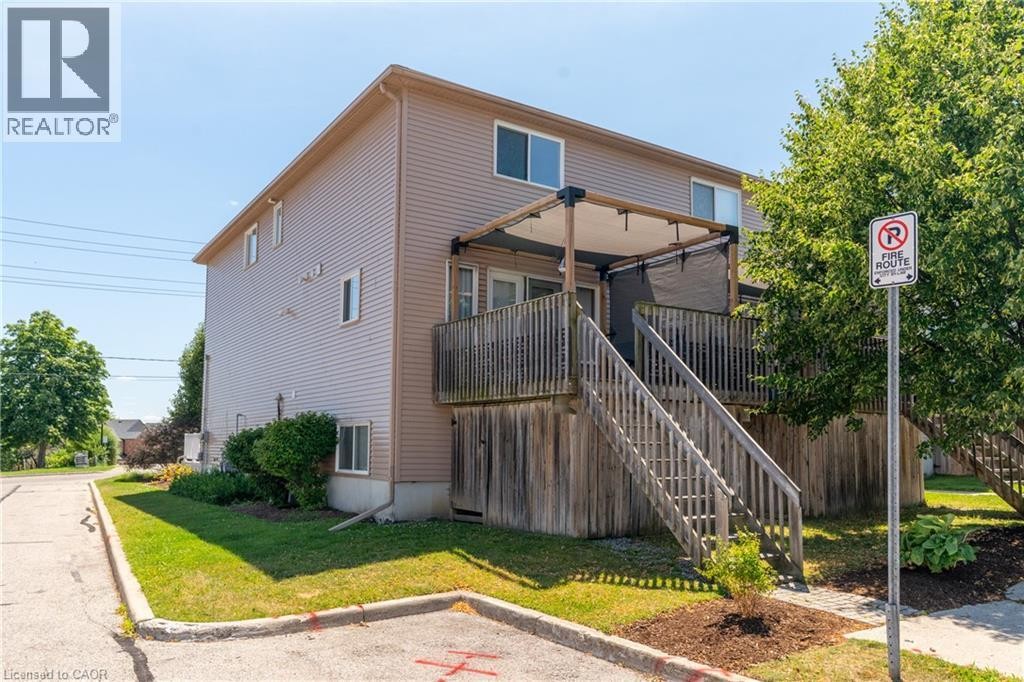 Second-story deck with wood railing and stairs - 50 Howe Drive Unit# 19B, Kitchener, ON