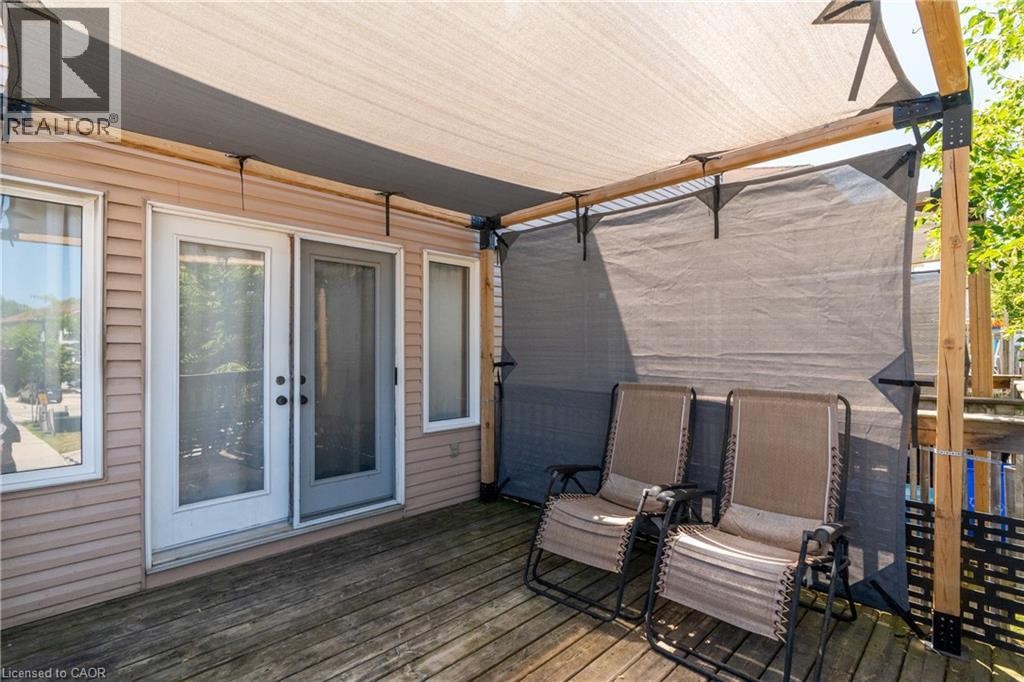 Expansive wooden deck with a retractable shade canopy and privacy screening - 50 Howe Drive Unit# 19B, Kitchener, ON