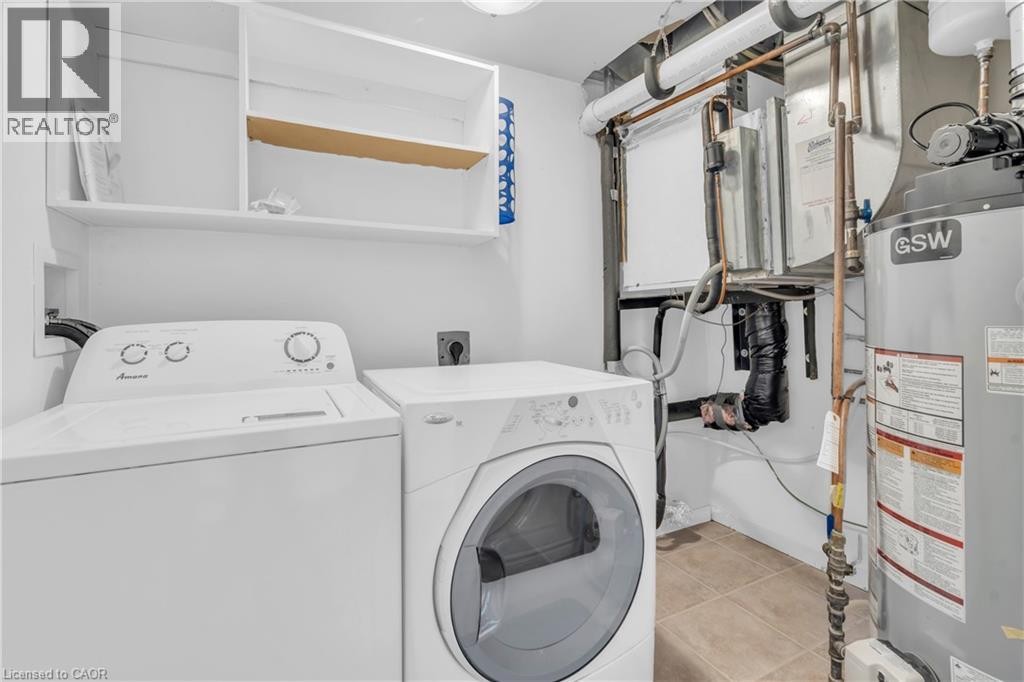Utility room with a top-load washing machine, front-load dryer, and built-in shelving - 50 Howe Drive Unit# 19B, Kitchener, ON