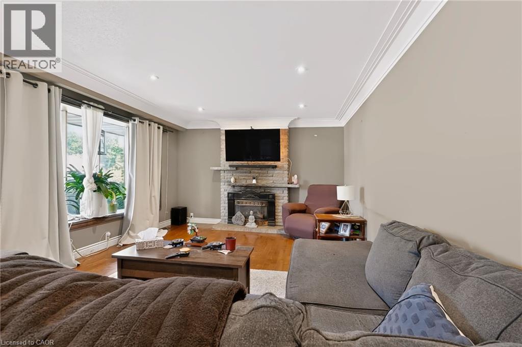 Hardwood flooring, recessed lighting, crown molding, stone-clad fireplace, and large windows - 1046 Shepherds Drive, Burlington, ON