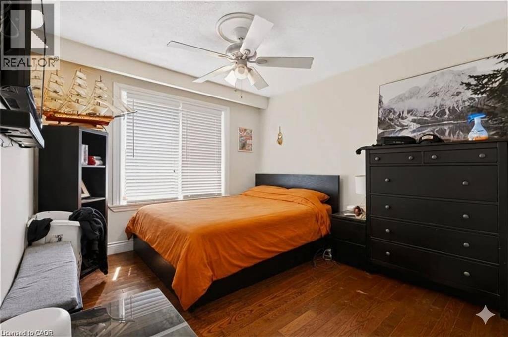 Wood-finish flooring with a ceiling fan light fixture - 1046 Shepherds Drive, Burlington, ON
