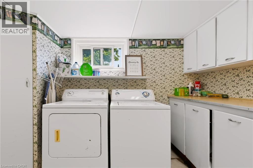Laundry area with built-in cabinetry, upper storage cabinets, and a window - 1046 Shepherds Drive, Burlington, ON