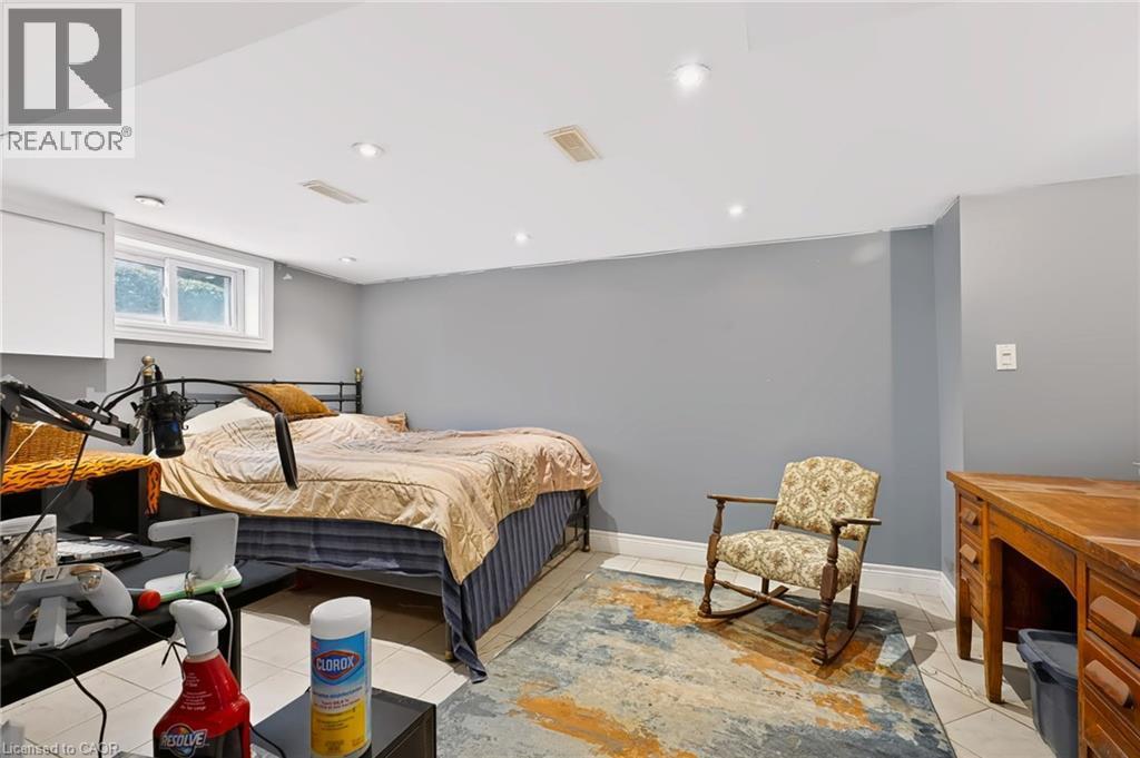 Recessed lighting, tile flooring, window with white trim, gray wall paint, and white baseboards - 1046 Shepherds Drive, Burlington, ON