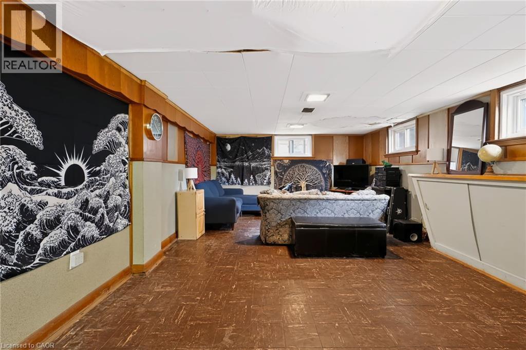 Wood-paneled walls and trim, wood-finish flooring, built-in lower cabinetry, and multiple windows - 1046 Shepherds Drive, Burlington, ON