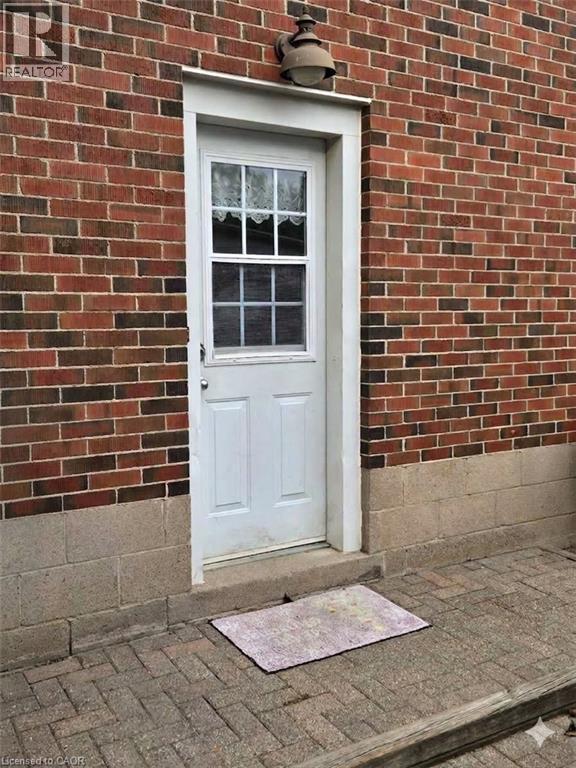 Brick exterior with a white paneled door featuring a window insert - 1046 Shepherds Drive, Burlington, ON