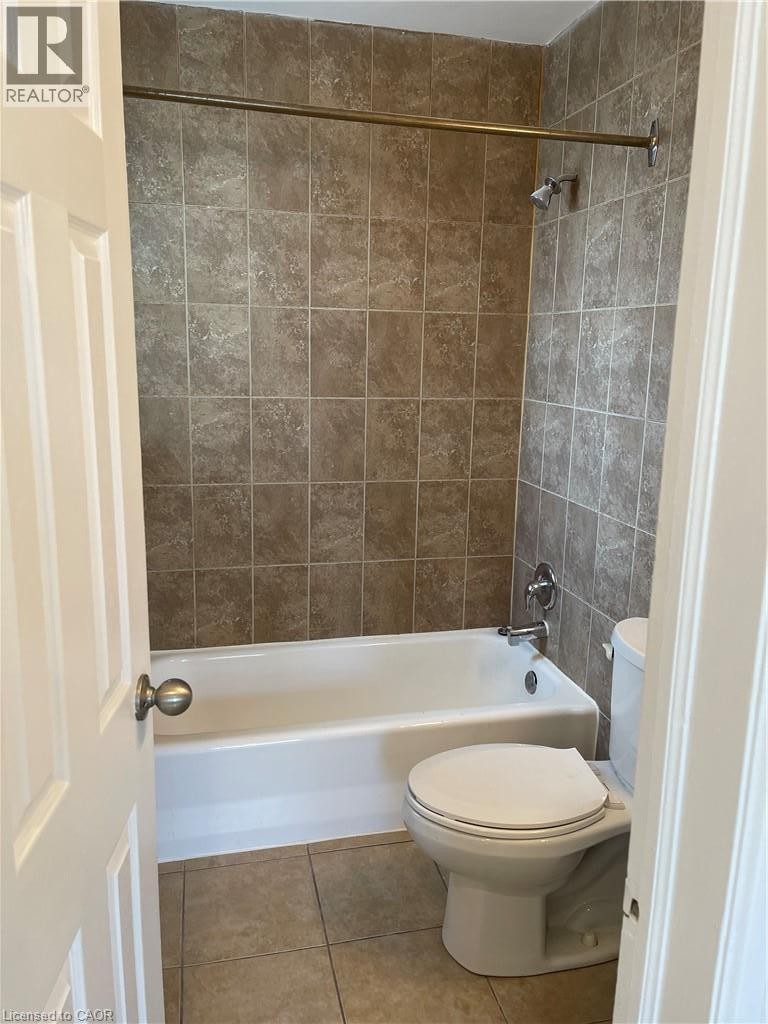Tiled shower surround with a white bathtub and chrome fixtures - 181 King Street E Unit# 14, Kitchener, ON