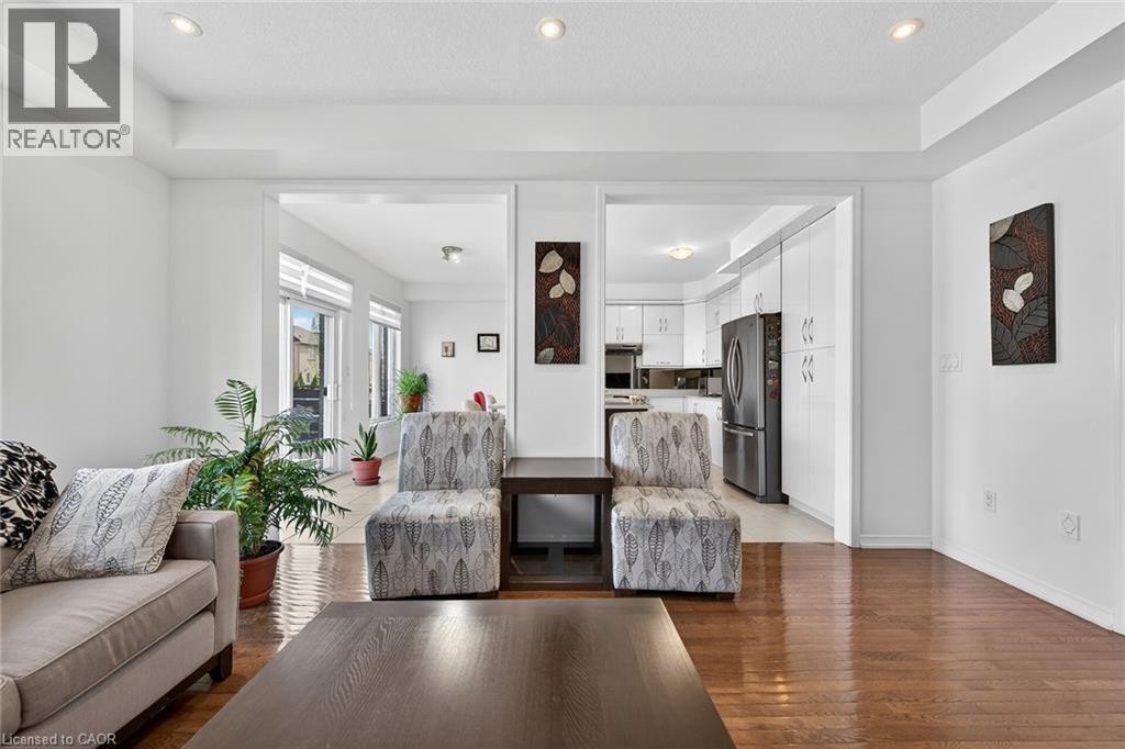 Living area with light wood-type flooring, recessed lighting, and a raised ceiling - 97 Sirente Drive, Hamilton, ON