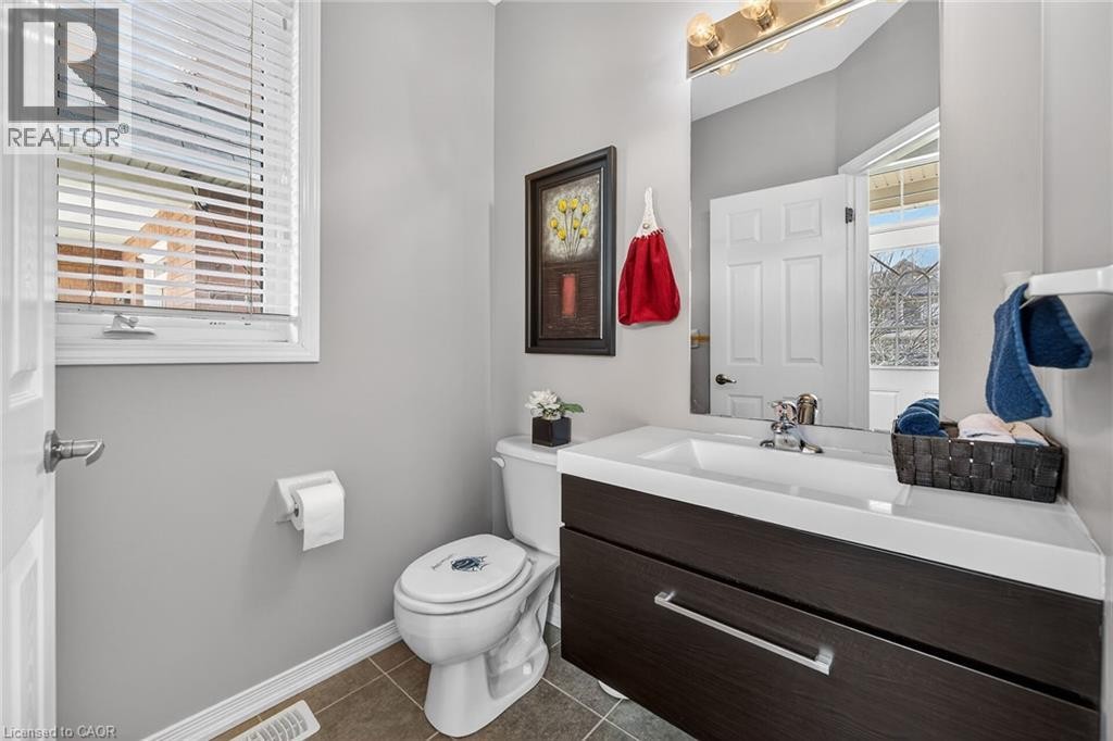 Half bath featuring vanity and dark tile patterned flooring - 97 Sirente Drive, Hamilton, ON