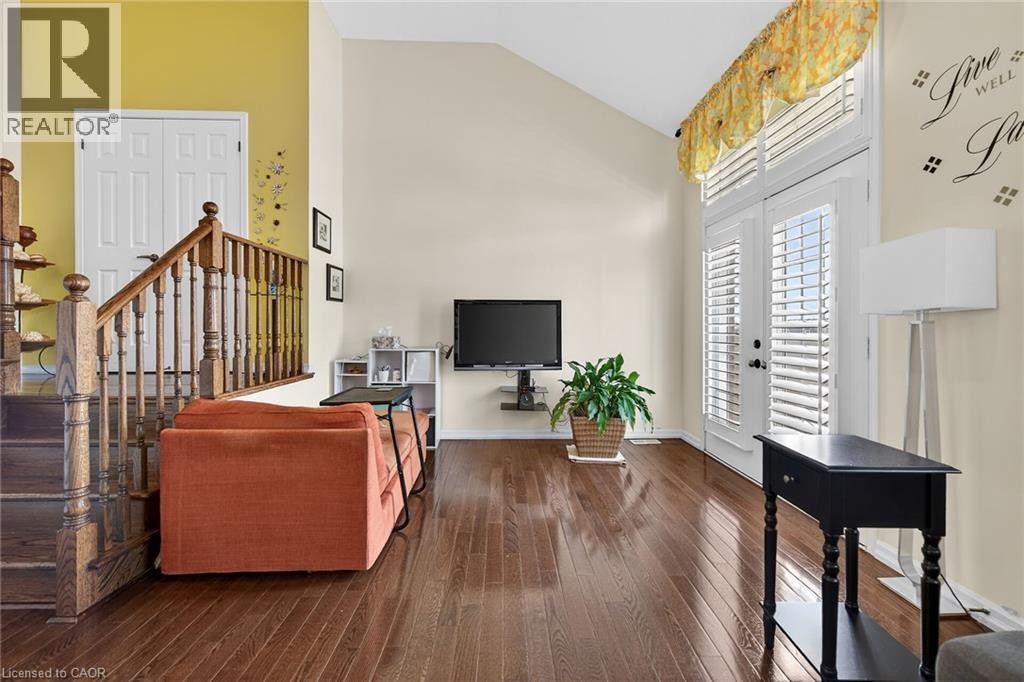 Living area with lofted ceiling and dark wood-style flooring - 97 Sirente Drive, Hamilton, ON