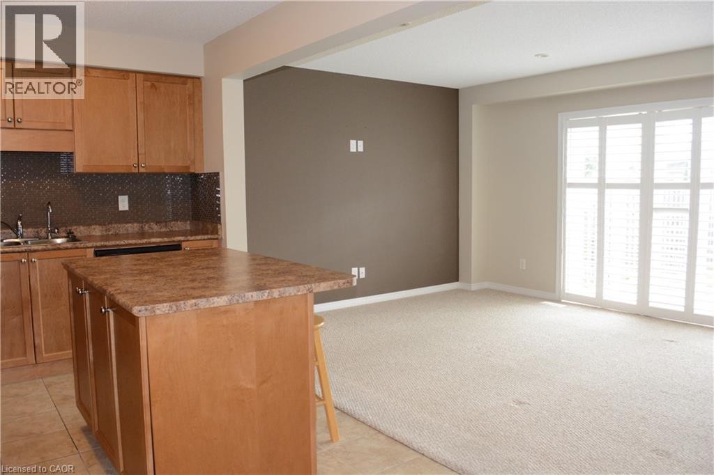 Kitchen with wood cabinetry, a central island with a countertop, and a diamond-patterned backsplash - 507 Beaumont Crescent, Kitchener, ON