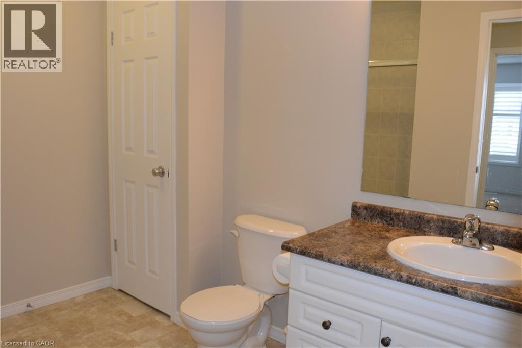 Bathroom featuring a single vanity with a laminate countertop, integrated sink, and chrome faucet - 507 Beaumont Crescent, Kitchener, ON