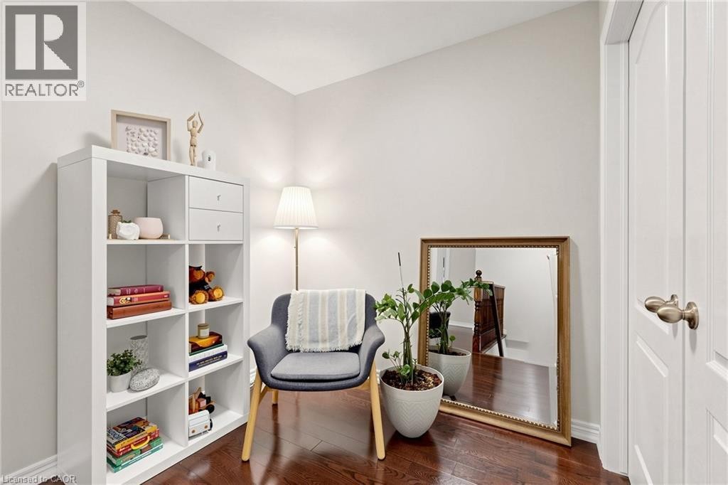 Rich wood-finish flooring, white paneled interior door with bronze hardware, and light neutral wall tones - 173 Raymond Road, Ancaster, ON