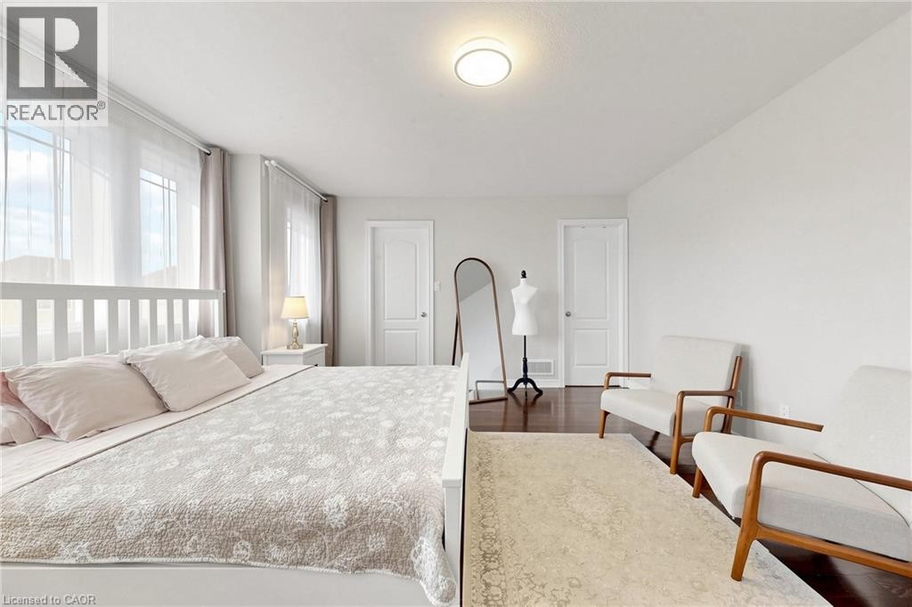 Spacious room with large windows, wood-finish flooring, two panel doors, and a ceiling-mounted light fixture - 173 Raymond Road, Ancaster, ON