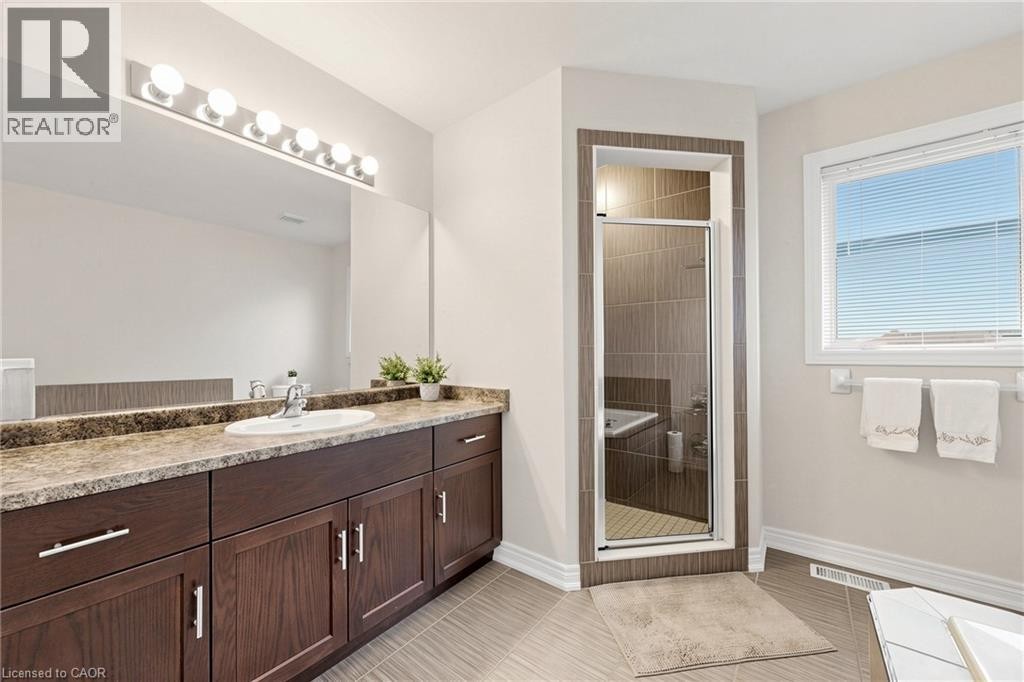 Spacious vanity with wood-finish cabinetry and stone-look countertop - 173 Raymond Road, Ancaster, ON