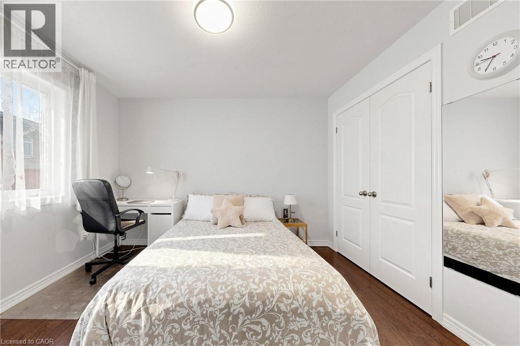 Wood-finish flooring, a double-door closet, and a built-in mirrored wardrobe - 173 Raymond Road, Ancaster, ON