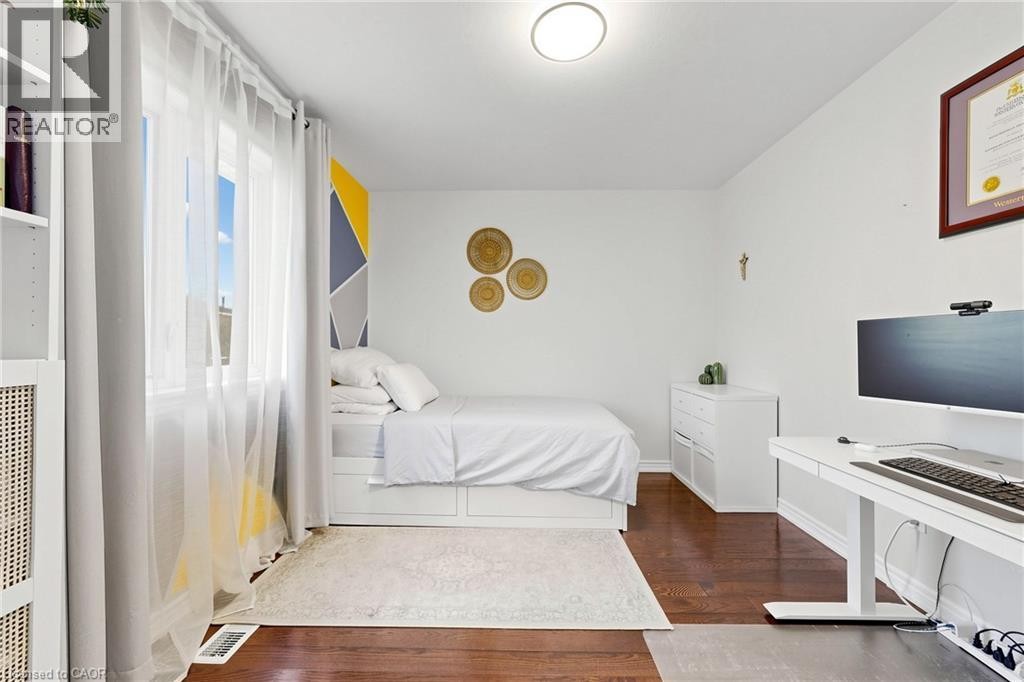Hardwood-finish flooring, white walls, and a large window with sheer drapes - 173 Raymond Road, Ancaster, ON