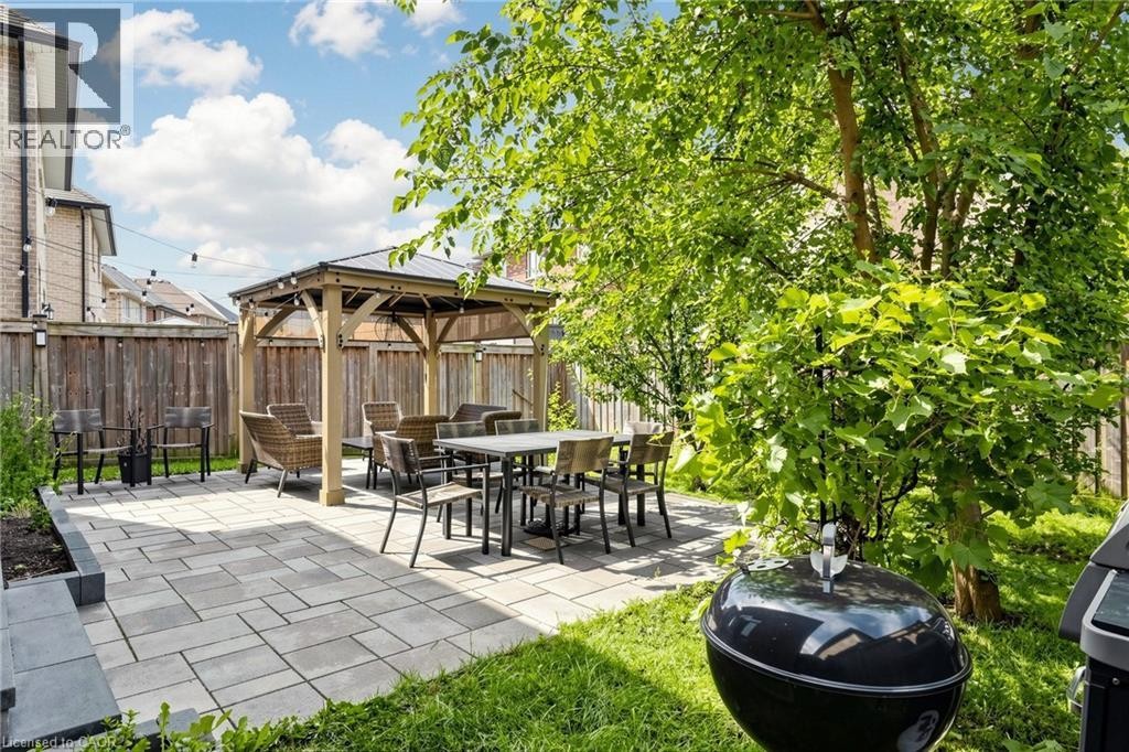 Expansive backyard featuring a paver patio, mature trees, and a wooden gazebo - 173 Raymond Road, Ancaster, ON