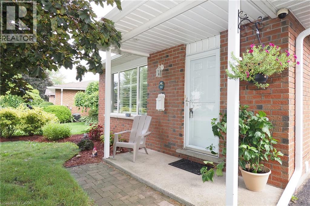 Red brick exterior with white trim, covered front entrance, and a paved walkway - 219 Foxhunt Road, Waterloo, ON