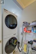 Dedicated laundry area featuring stacked front-loading appliances - 