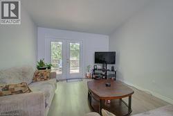 Living space featuring light wood-finish flooring and white walls - 