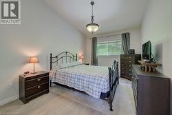 Bedroom featuring neutral wall tones, vaulted ceiling, and a central pendant light fixture - 