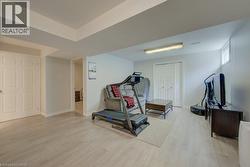 Spacious finished lower level featuring light wood-finish flooring, neutral wall tones, white trim, and recessed lighting - 