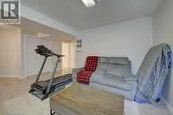 Finished lower level featuring light-toned wood-finish flooring and neutral painted walls - 