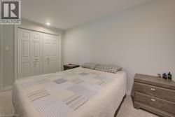 Recessed lighting illuminates this room, featuring light-colored walls and carpet flooring - 