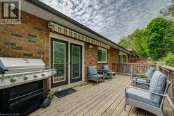 Spacious outdoor deck featuring wood-finish decking and a wooden railing - 