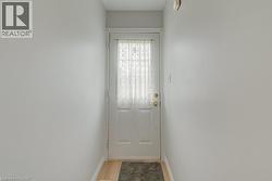 White paneled door with a privacy curtain, brass hardware, and light wood-finish flooring - 