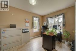 Room featuring light-toned wood-finish flooring and two windows with white trim - 