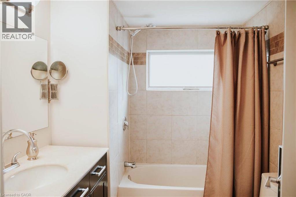 Built-in bathtub with subway tile surround, integrated shower, and a privacy window - 1 Vera Court, Hamilton, ON