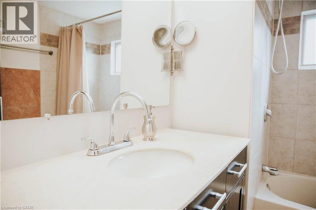 Built-in vanity with an integrated sink, chrome faucet, and dark-finish cabinetry - 1 Vera Court, Hamilton, ON