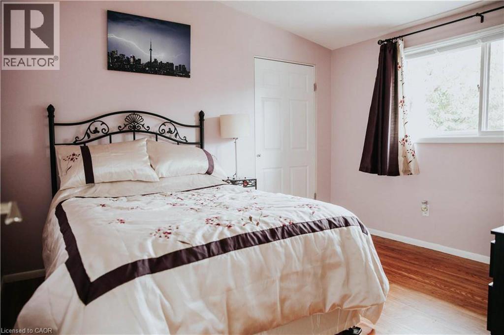 Hardwood-style flooring, white paneled door, and a white-framed window - 1 Vera Court, Hamilton, ON
