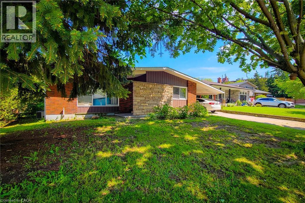 Brick exterior with stone accents, a single-pane window, and an attached carport - 1 Vera Court, Hamilton, ON