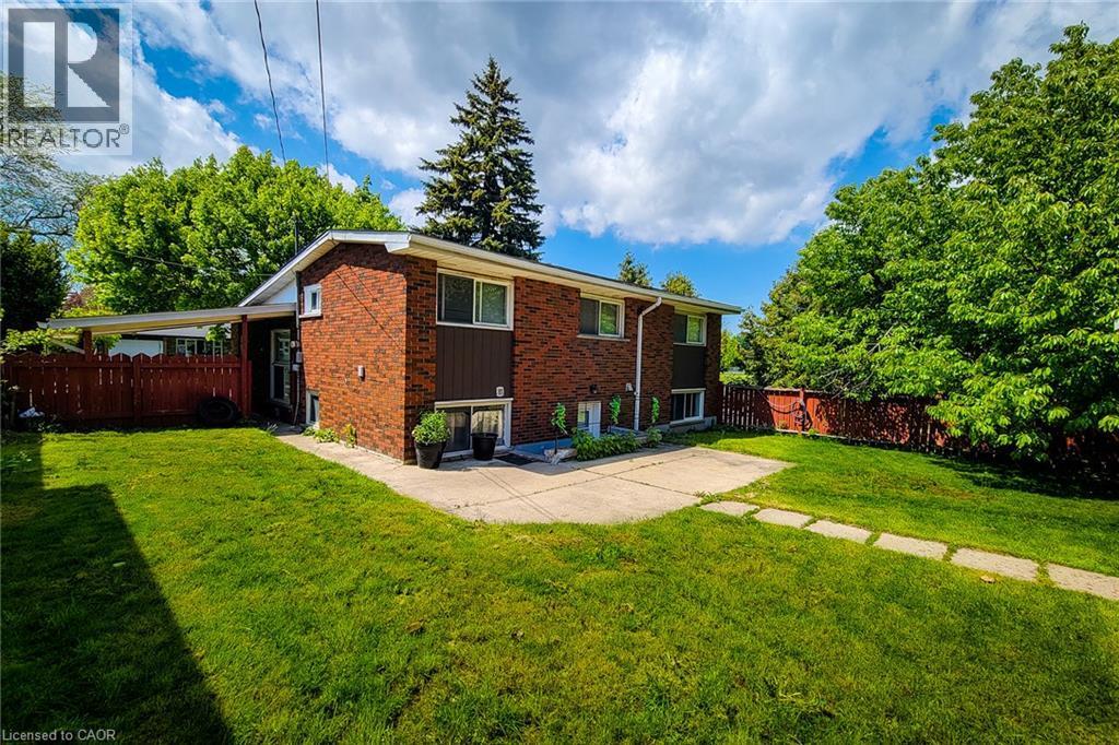 Brick exterior with white trim, concrete walkway, and a spacious lawn - 1 Vera Court, Hamilton, ON