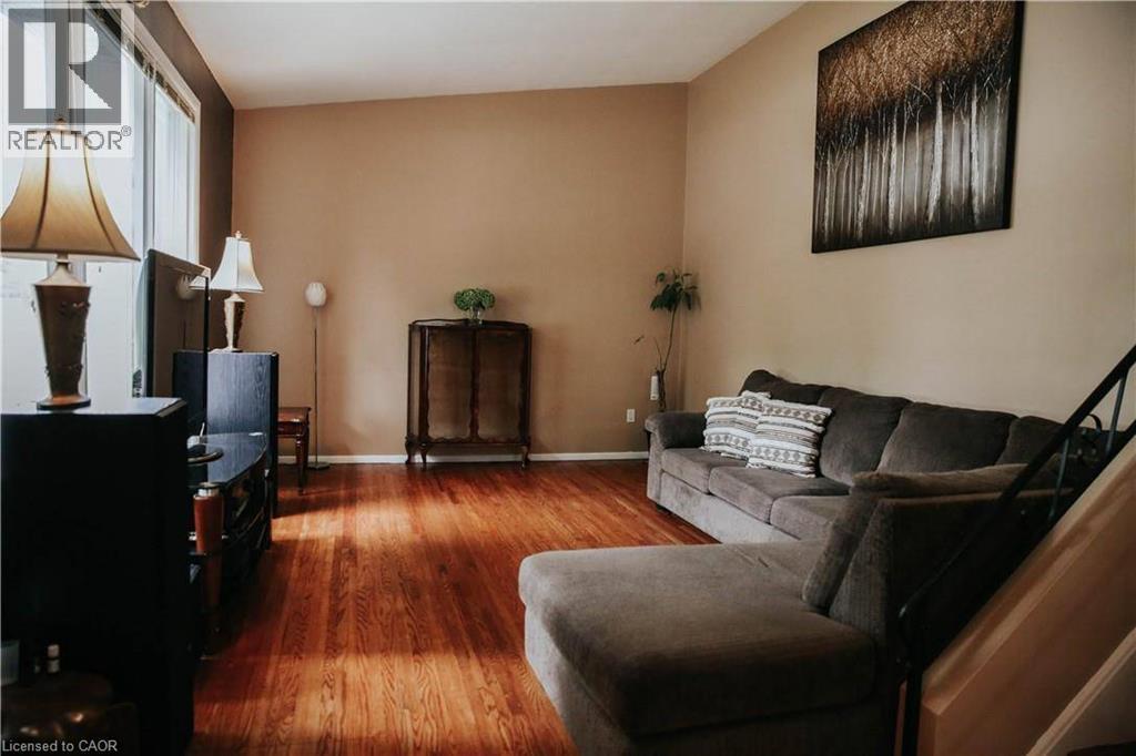 Wood-finish flooring, neutral wall tones, and ample natural light from large windows - 1 Vera Court, Hamilton, ON