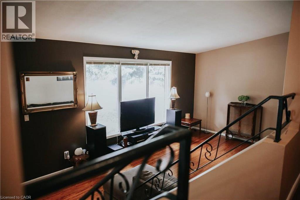 Hardwood flooring, painted walls, large window, and wrought iron railing - 1 Vera Court, Hamilton, ON