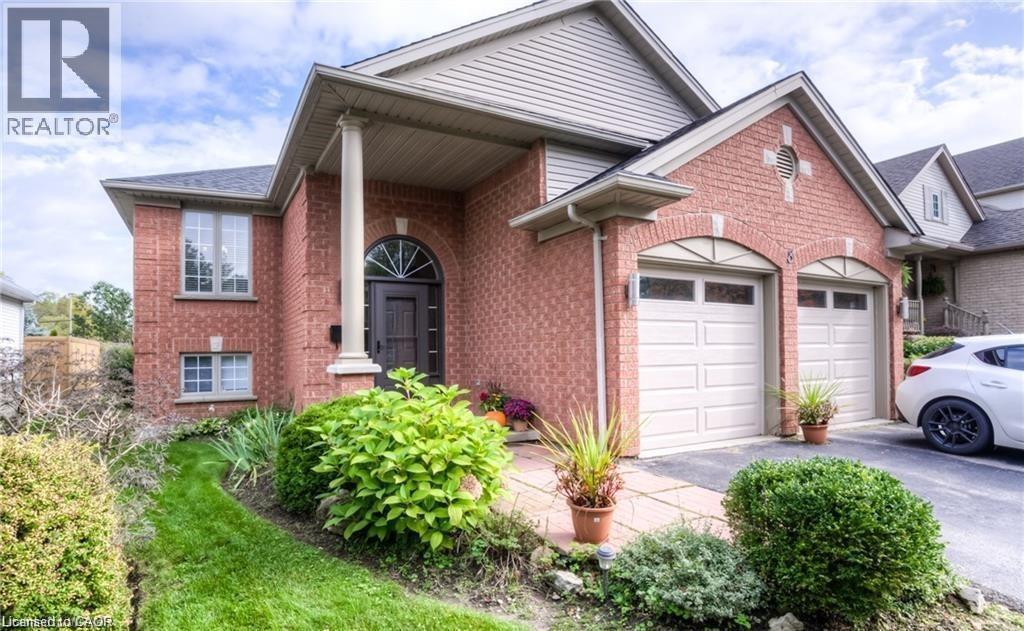 Brick exterior featuring a covered entry with a column, an arched transom entry door, and a two-car garage with arched detailing - 8 Melran Drive Unit# 2, Cambridge, ON
