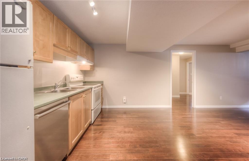 Kitchenette with light wood-finish cabinetry, stainless steel dishwasher, and track lighting - 8 Melran Drive Unit# 2, Cambridge, ON