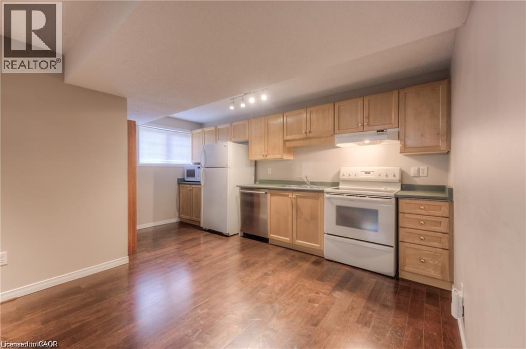 Wood-finish flooring, light wood cabinetry, white kitchen appliances, and track lighting - 8 Melran Drive Unit# 2, Cambridge, ON