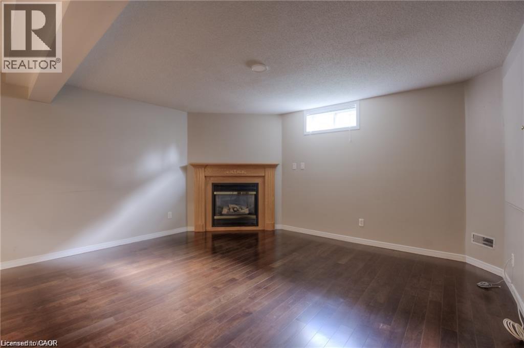 Wood-finish flooring, recessed lighting, and a fireplace with a wood mantle - 8 Melran Drive Unit# 2, Cambridge, ON