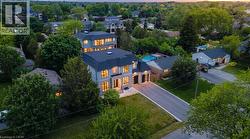 Stone and stucco exterior with multiple gables, an asphalt driveway, and a backyard swimming pool - 