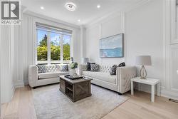 Living space featuring expansive window, light wood-finish flooring, recessed lighting, and detailed wall paneling - 