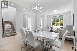 Bright dining area featuring light wood-finish flooring and extensive wall paneling - 